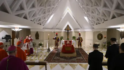 EPA-Ife/Rex/Shutterstock. Il corpo di Papa Francesco si trova in una bara aperta nella Cappella di Santa Marta, la città del Vaticano, circondata dalle guardie degli svizzeri e dei crimini in preghiera.